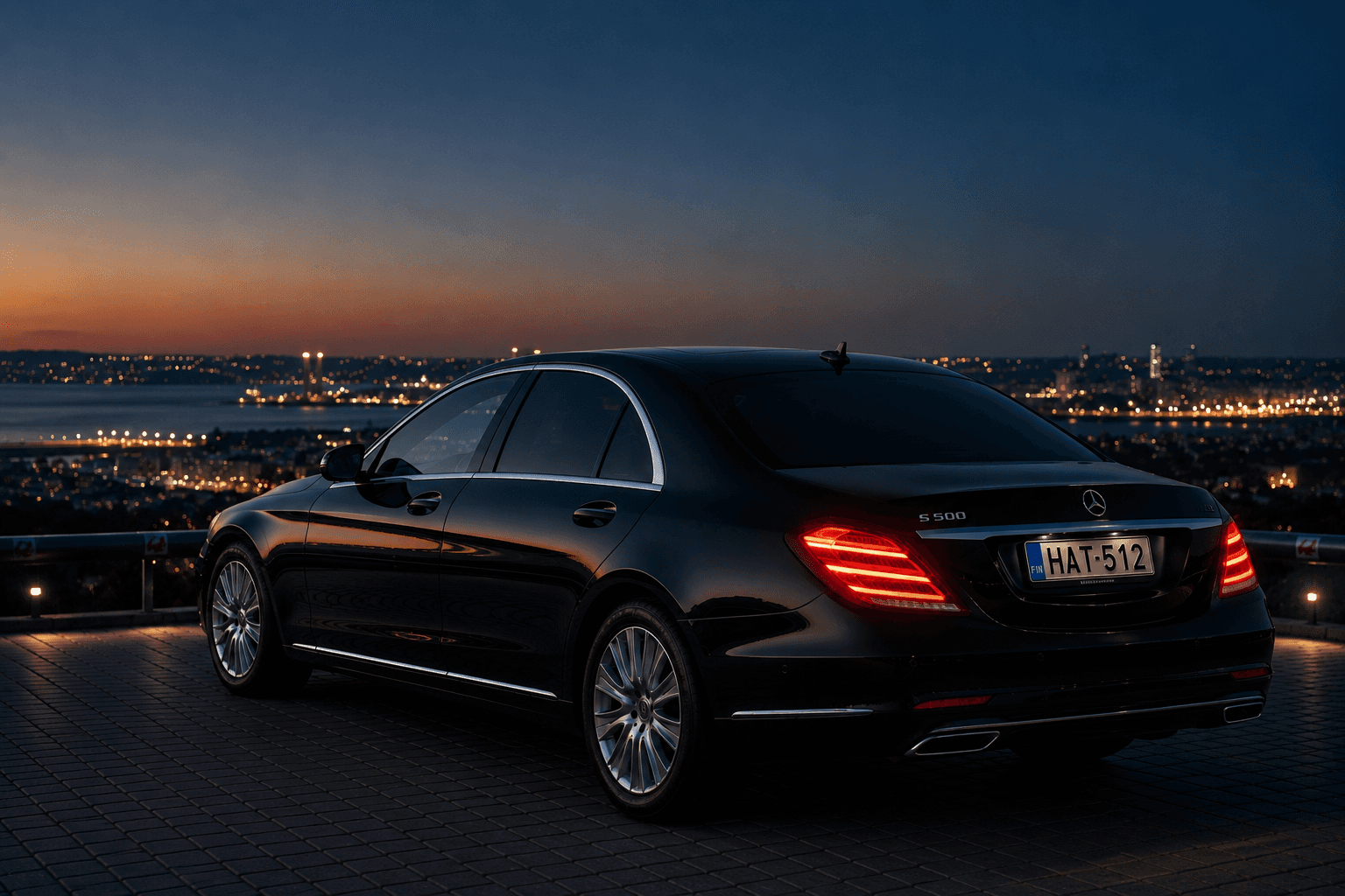 Black Mercedes S-Class with Helsinki Airport Taxi plates at dusk overlooking the city